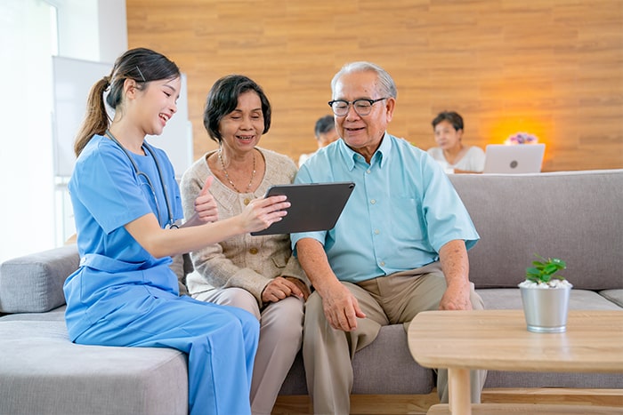 a nurse showing info to the elderly couple